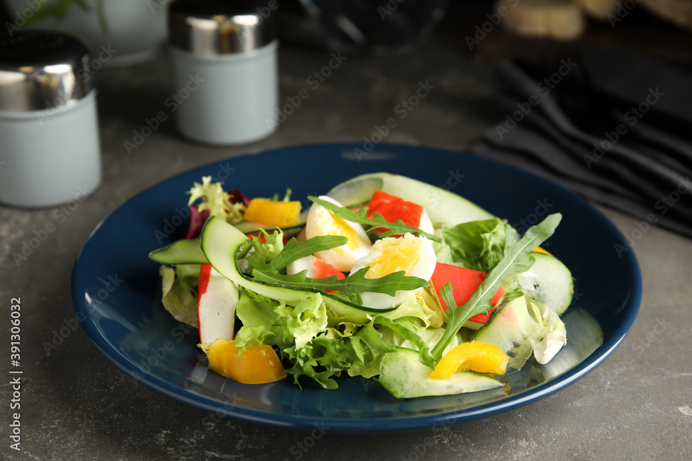 Delicious salad with crab sticks and lettuce on grey table, closeup