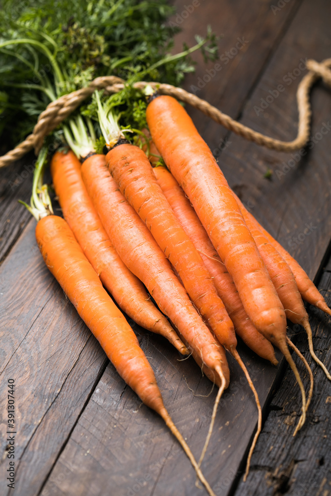 Fresh carrots bunch on rustic background. Healthy vegan vegetable food. Fresh carrots bunch on rustic background. Healthy vegan vegetable food.