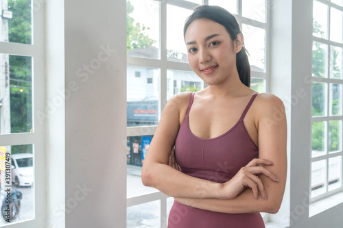 Portrait of Asian smiling woman in wearing sportswear standing in arms crossed pose looking at camera in studio. healthy lifestyle people concept. copy space