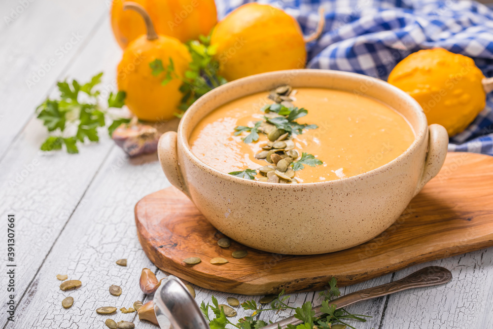 Pumpkin soup with roasted pumpkin seeds on white wooden table, top view, copy space. Seasonal autumn food Pumpkin soup with roasted pumpkin seeds on white wooden table, top view, copy space. Seasonal autumn food