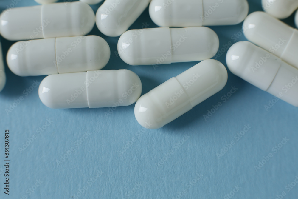 White pills on blue background White pills on blue background