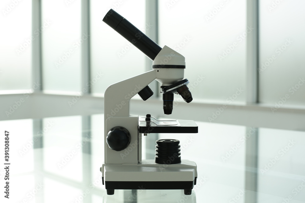 Microscope on a glass table in a bright room