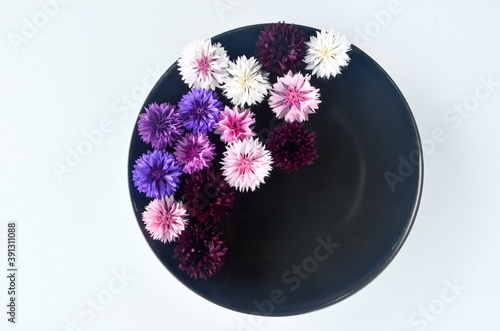 Different colored flower mandala on floating on water plate made of fresh flowers. Floral background with nature flowers. Flower mosaic