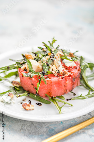 summer watermelon salad with blue cheese , arugula on light background. Healthy food, clean eating