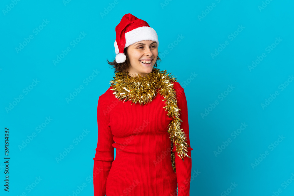 English girl with christmas hat isolated on blue background looking side English girl with christmas hat isolated on blue background looking side