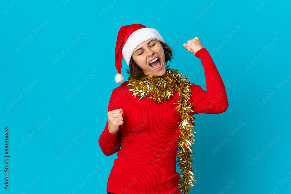 English girl with christmas hat isolated on blue background celebrating a victory English girl with christmas hat isolated on blue background celebrating a victory