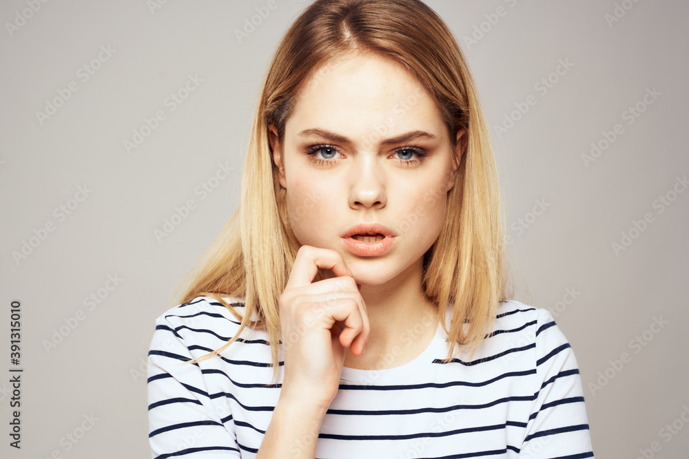 Emotional blonde woman in striped t-shirt lifestyle facial expression close-up Emotional blonde woman in striped t-shirt lifestyle facial expression close-up