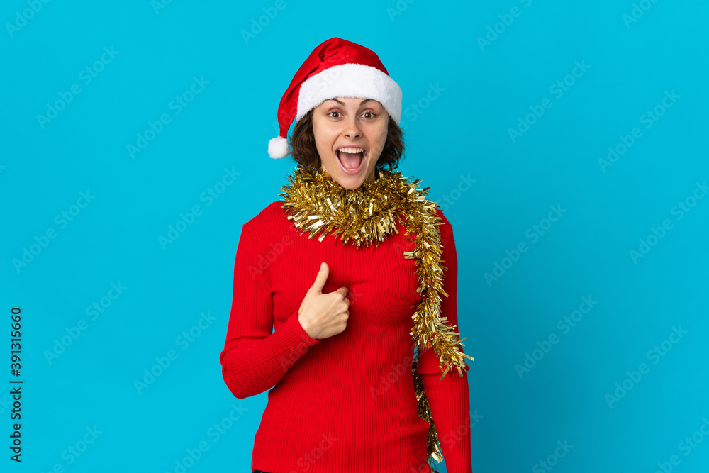 English girl with christmas hat isolated on blue background with surprise facial expression English girl with christmas hat isolated on blue background with surprise facial expression