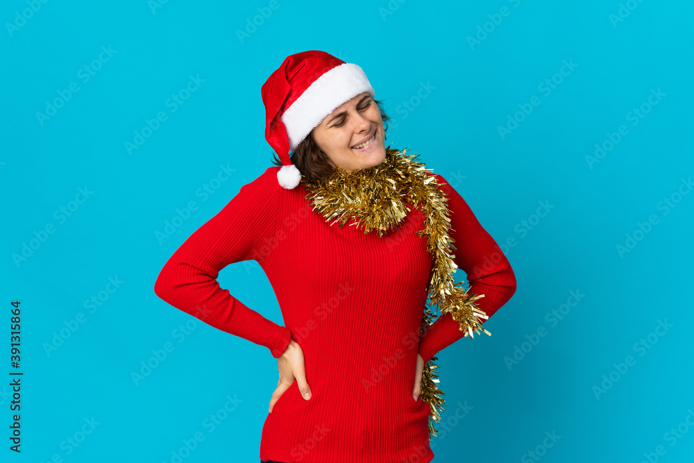 English girl with christmas hat isolated on blue background suffering from backache for having made an effort English girl with christmas hat isolated on blue background suffering from backache for having made an effort