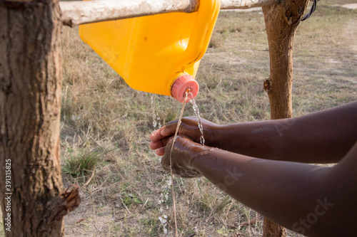 Photography Pouring water from the innovation tool called tippy tap made of 5 liter can of w