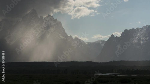 Timelapes from of cloudy and snowy Grand Tetons in Grand Teton National Park with storm clearing and reflection in clouds, Wyoming   photo