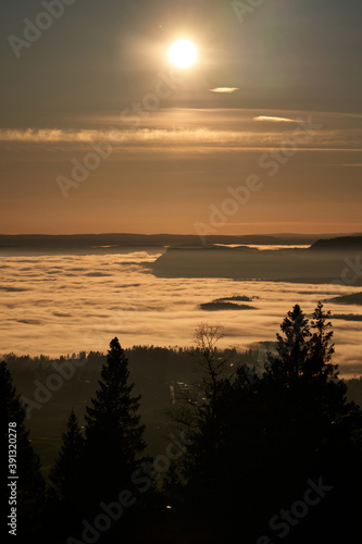 The fog is dense and like a lid on top of Oslo  Norway. Clear sky above the fog and it almost loos like clouds. Shot in golden hour and blue hour to get the best light. Shot from Holmenkollen. 