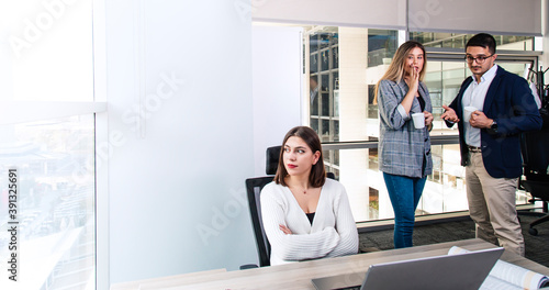Fototapeta Turkish white collar woman is working on desk and there are two colleagues are g