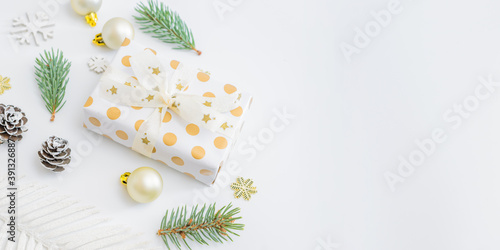 Frame with fir branches, christmas baubles decoration and gift box on a white background