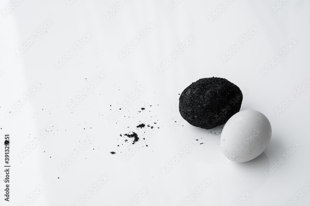 Fototapeta premium An old duck egg recipe in ash. Salty pickled duck egg in ash on a white background