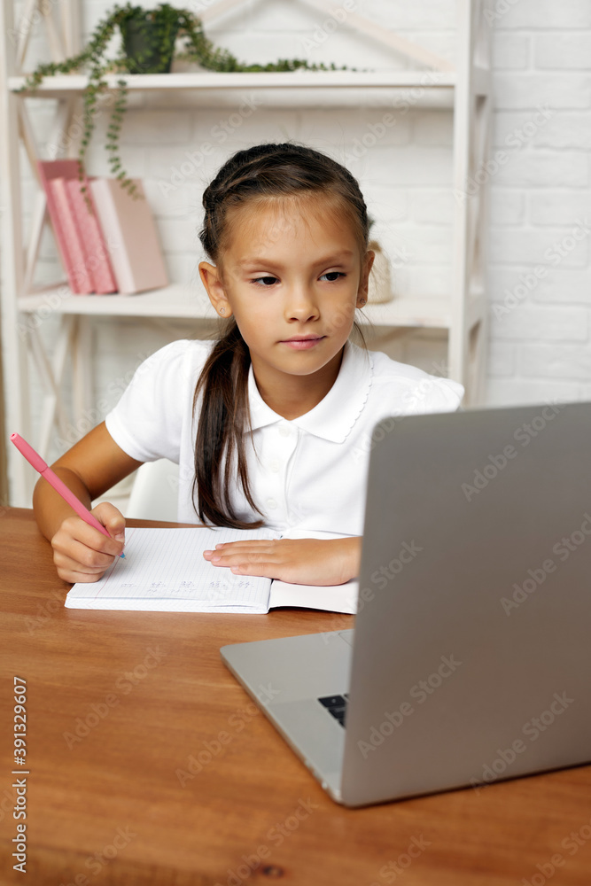 happy little child girl using laptop for studying online e-learning system. happy little child girl using laptop for studying online e-learning system.