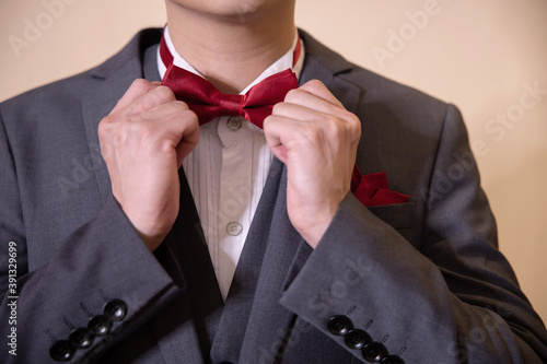 A Man Ties a Bowtie in the Morning Before the Wedding Ceremony
