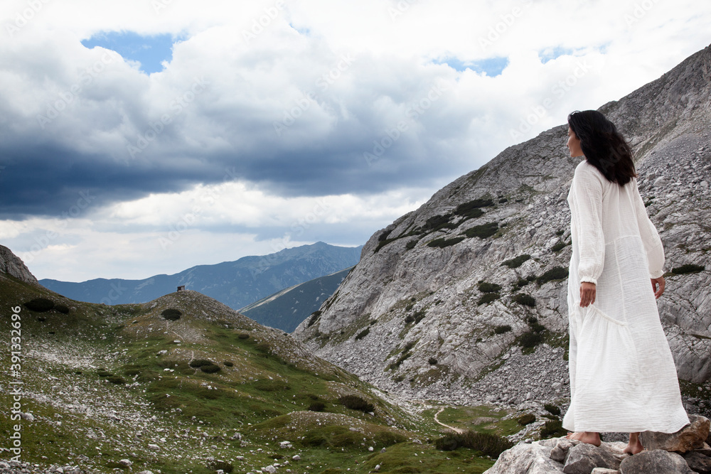 Fototapeta premium A woman in a white dress on the highest mountain in Bulgaria