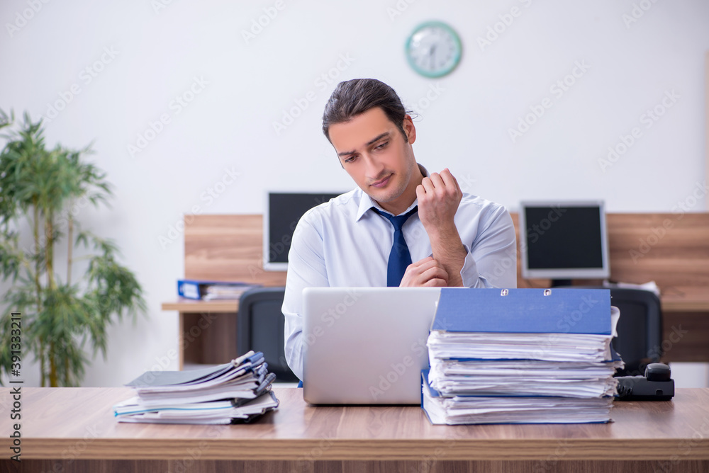 Young male employee unhappy with excessive work Young male employee unhappy with excessive work
