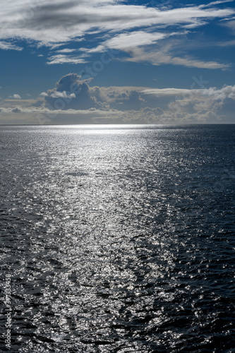 Cloudy blue sky leaving for horizon above a blue surface of the North Sea © Olaf