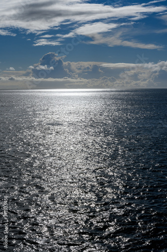 Cloudy blue sky leaving for horizon above a blue surface of the North Sea