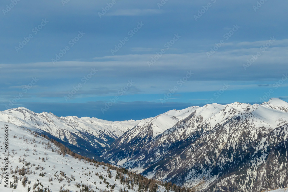 A panoramic view on snow capped Alps in Austria, seen from Katschberg Ski Resort in Austria.The slopes are covered with fresh, powder snow. Idyllic winter landscape. Sunny day A panoramic view on snow capped Alps in Austria, seen from Katschberg Ski Resort in Austria.The slopes are covered with fresh, powder snow. Idyllic winter landscape. Sunny day