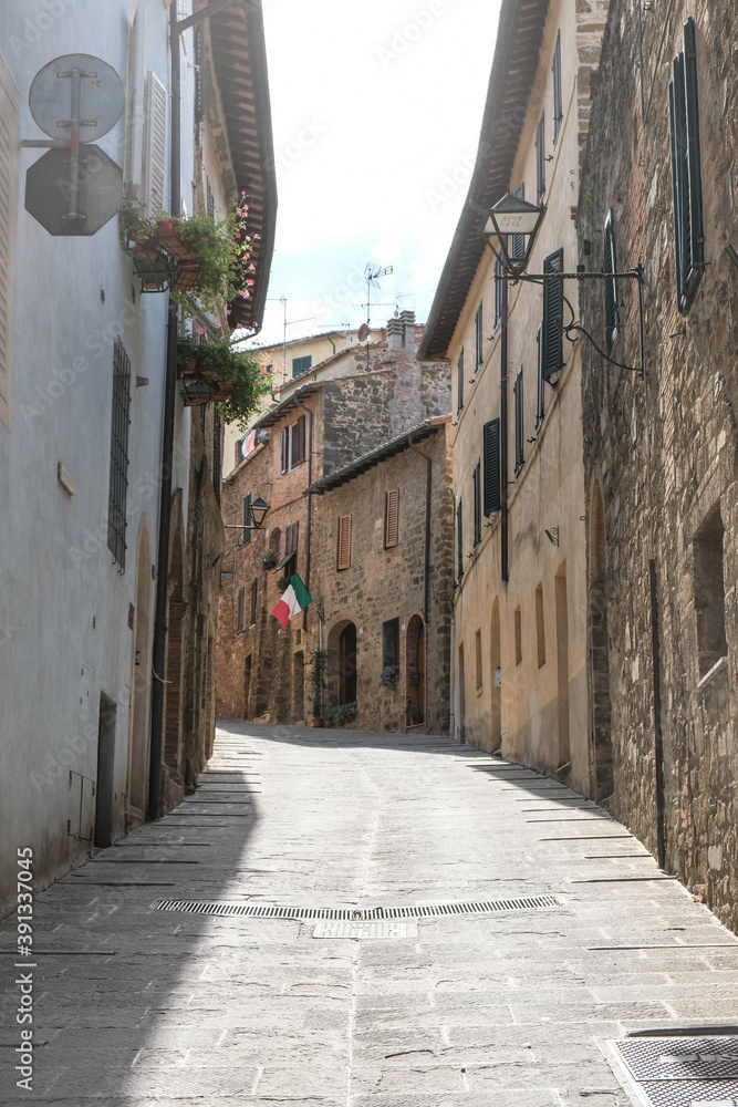 Authentic street with view in small village in tuscany in Italy with brown stones houses