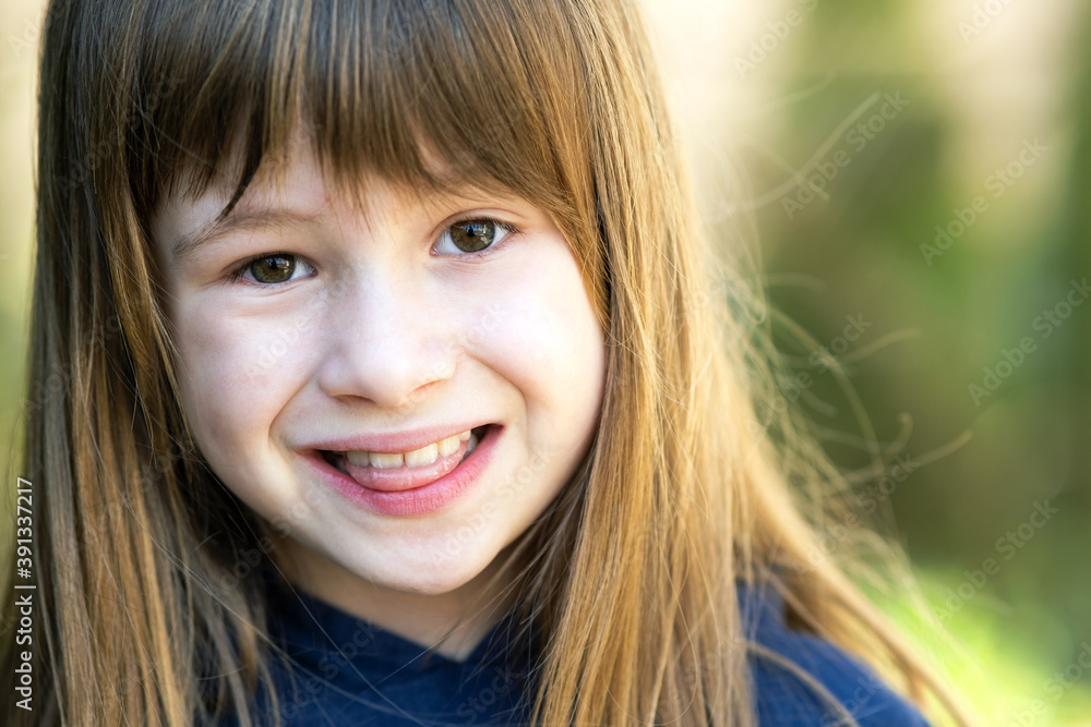 Portrait of pretty child girl with gray eyes and long fair hair outdoors on blurred green bright background. Cute female kid on warm summer day outside. Portrait of pretty child girl with gray eyes and long fair hair outdoors on blurred green bright background. Cute female kid on warm summer day outside.