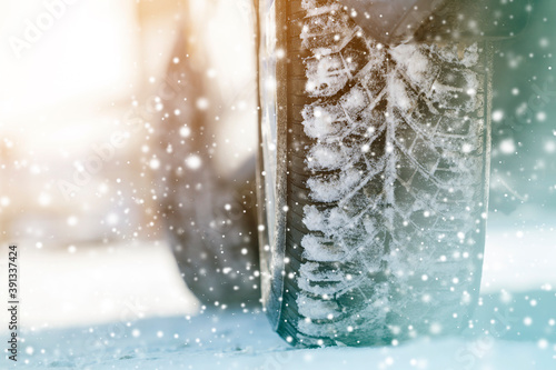 Close-up of car wheels rubber tires in deep winter snow. Transportation and safety concept.