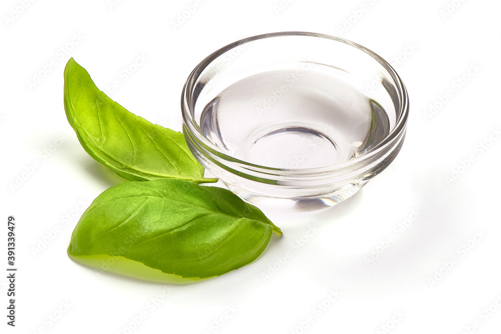 White Vinegar in a glass bowl with basil leaves, isolated on white background White Vinegar in a glass bowl with basil leaves, isolated on white background