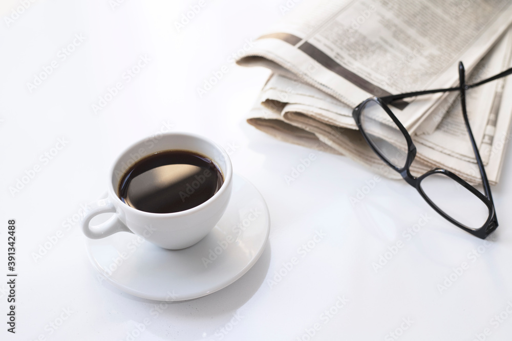 Coffee cup with newspaper and glasses on white table.Take a break. Coffee cup with newspaper and glasses on white table.Take a break.