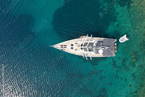 Aerial view of a sailing yacht in a cristally blue sea on a hot sunny day in summer photo