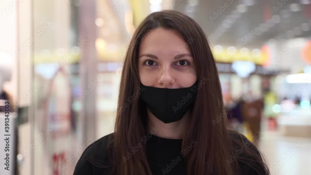 Caucasian young woman with black reusable mask. covid-19 pandemic. wrong wear of face mask Caucasian young woman with black reusable mask. covid-19 pandemic. wrong wear of face mask