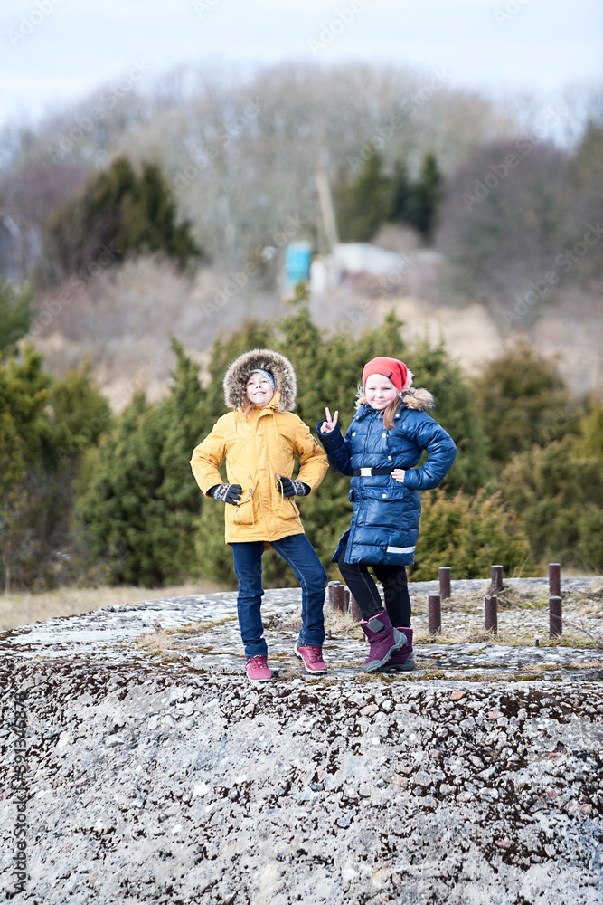 Portrait of two young girls walking together, warm clothing at winter season
