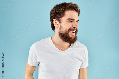 Emotional man with a beard in a white t-shirt blue background fun lifestyle
