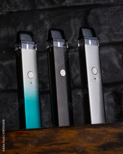 Vaping pen, vape devices, mods for electronic cigarette or e cigarette, e cig, on a wooden background. photo