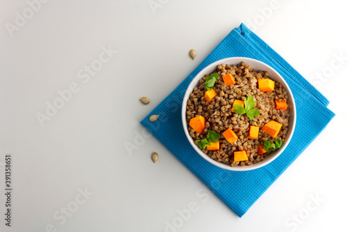 Buckwheat porridge with pumpkin and pasley in a white bowl. Russian cuisine photo