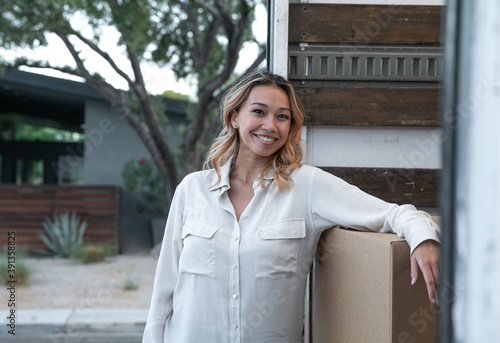 Happy Millennial Looking at Camera Outside a Moving Truck photo