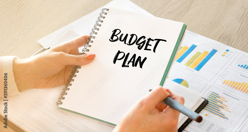 A business woman sitting at a table in a light office looks into a notebook for notes. Planning, goals, plan. Close-up, soft light. A business woman sitting at a table in a light office looks into a notebook for notes. Planning, goals, plan. Close-up, soft light.