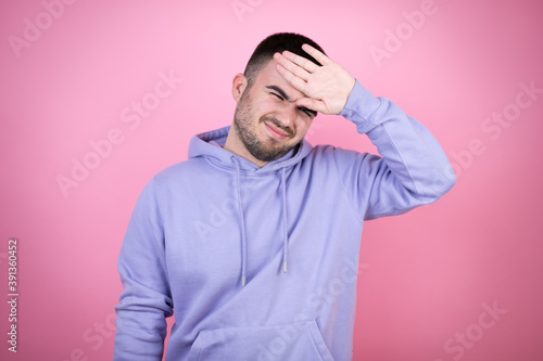 Young handsome man wearing casual sweatshirt over isolated pink background Touching forehead for illness and fever  flu and cold  virus sick