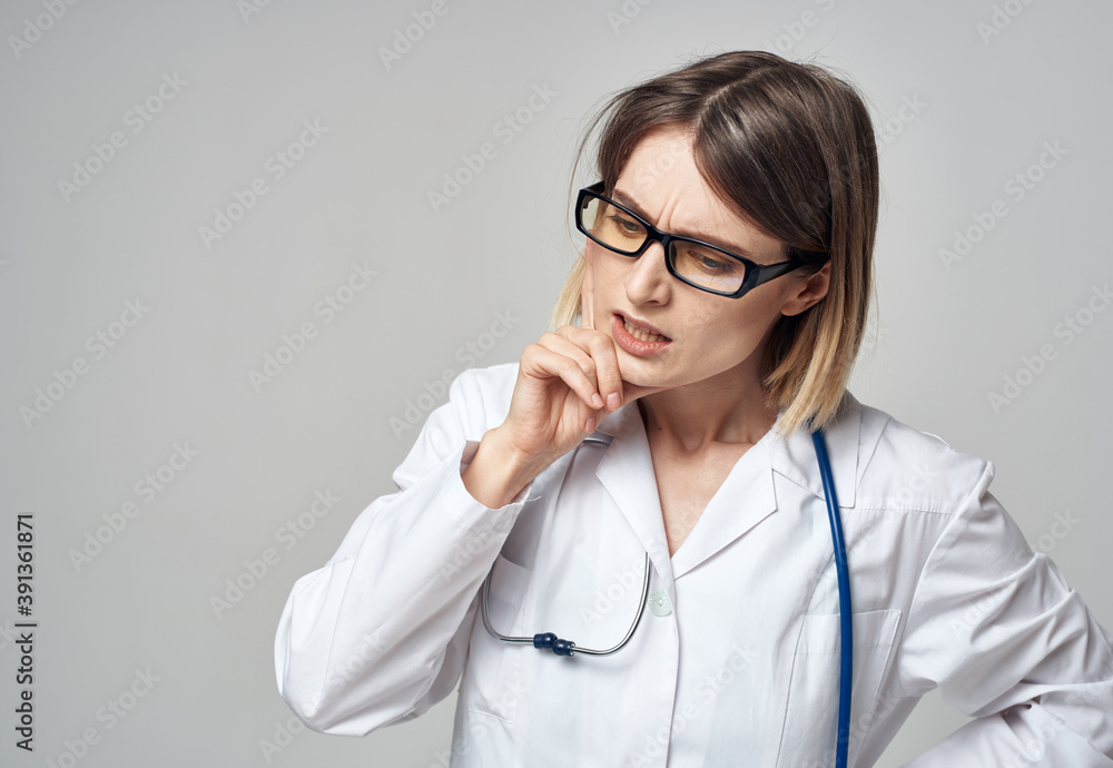 doctor in a medical gown with a stethoscope around his neck puzzled look gray background doctor in a medical gown with a stethoscope around his neck puzzled look gray background