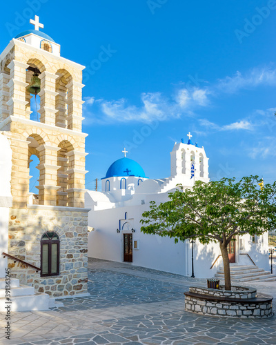 Traditional Cycladitic alley with a narrow street, whitewashed houses and a church in kostos Paros island, Greece