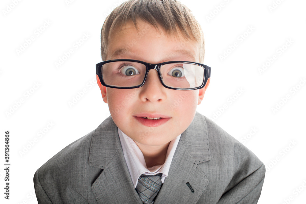 Portrait of a funny child in glasses and a business suit on a white background. Smart child in suit and glasses looking at camera with his big eyes