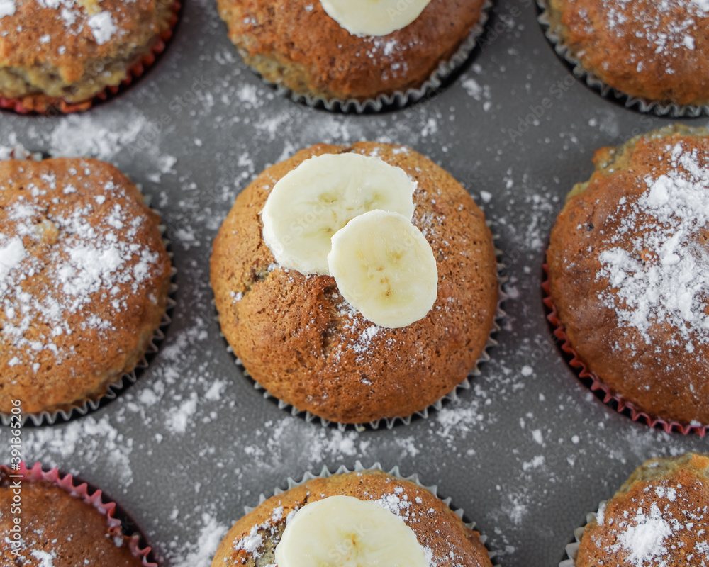Baking background, Homemade muffins with banana in grey baking mold Baking background, Homemade muffins with banana in grey baking mold