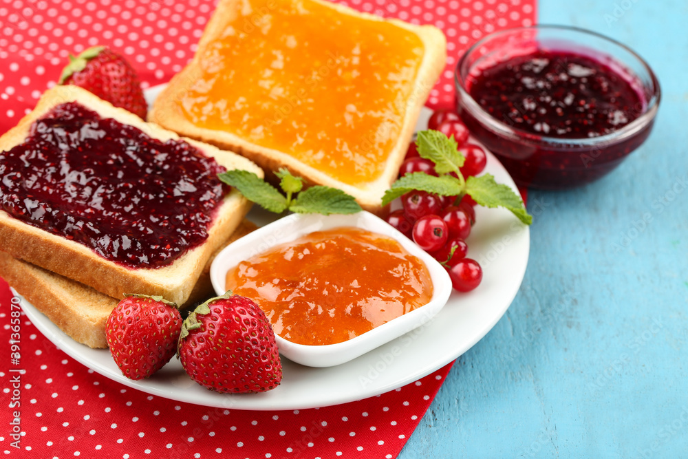Toasts with jam with fresh berries on blue wooden table Toasts with jam with fresh berries on blue wooden table