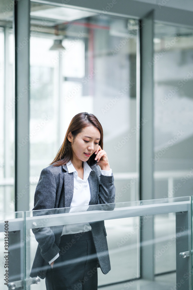 Businesswoman Using Cell Phone In Office Buildings Businesswoman Using Cell Phone In Office Buildings