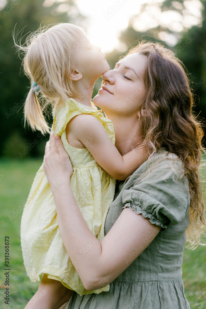 Pregnant woman and small girl embracing in park Pregnant woman and small girl embracing in park