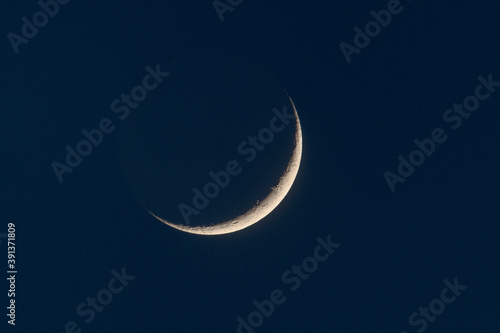 growing moon shot with super-tele lens in the dusk