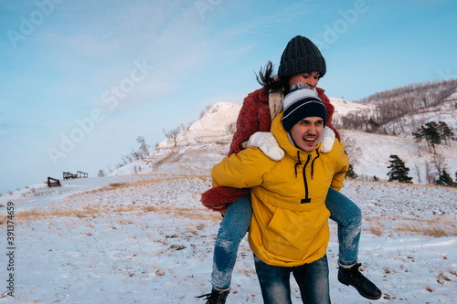 Winter love story. Young couple having fun in the mountains photo