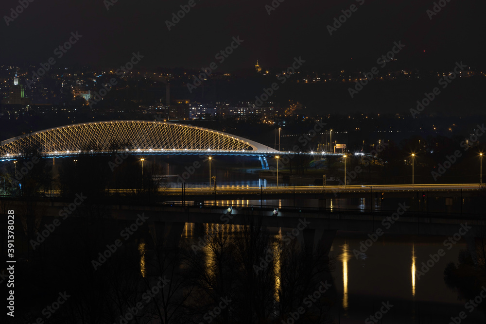 Obraz premium view of street lighting on bridges on the Vltava river in the city of Prague at night and lights from passing cars